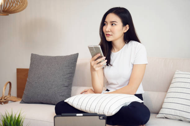 istock Asian woman are thinking while holding a cell phone 1318629528