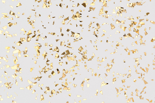 El confeti dorado brilla sobre el fondo blanco, el papel de oro, el telón de fondo festivo. photo