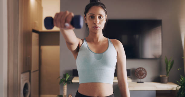 istock Shot of a young woman working out using weights at home 1318637579