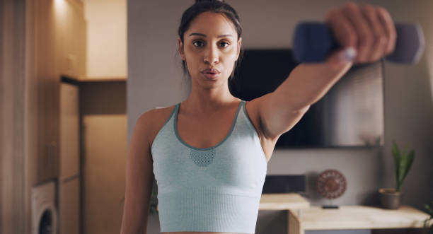 istock Shot of a young woman working out using weights at home 1318637583