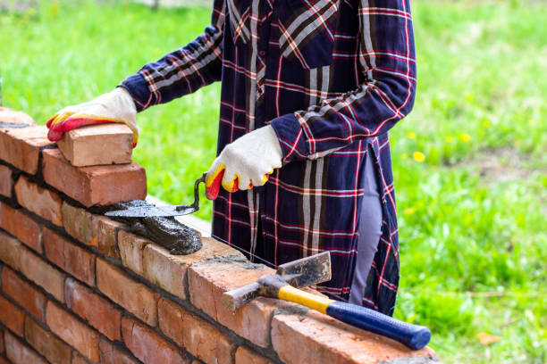 istock a young female bricklayer lays out cement mortar for laying bricks with a trowel on a brick wall 1318637649