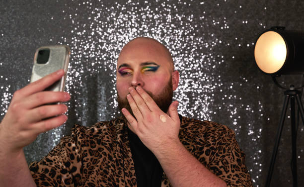 istock Shot of a young man using a smartphone while applying theatrical makeup in a studio 1318638733