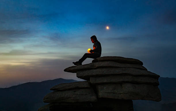 istock A man is holding a lamp under the moon 1318639928