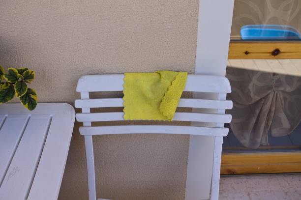 A yellow rag leaning against a white chair on the balcony (Pesaro, Italy, Europe)