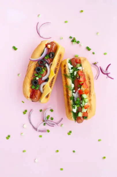 Photo of Flat lay of delicious hot dogs with vegetables and sausages.