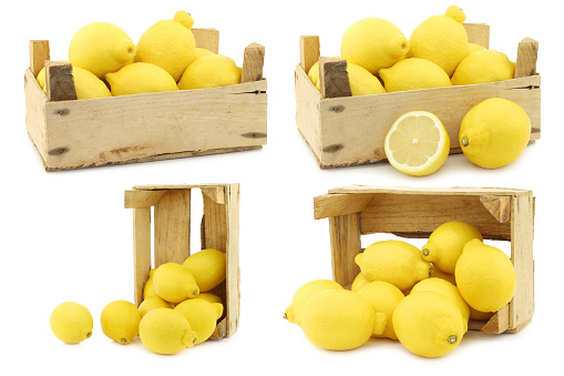 Fresh lemons in a wooden crate on a white background