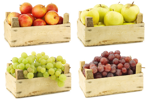 Mixed fruits in a wooden crate on a white background