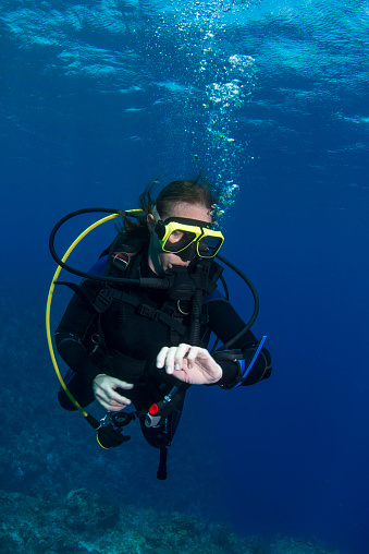 View of a female diver checking the dive computer at the safety stop