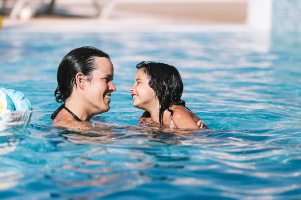 istock Mother and daughter playing in the pool 1318651968