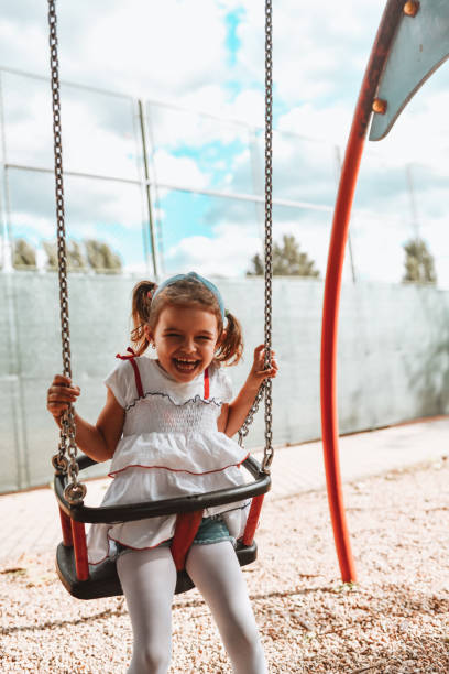 istock Smiling Female Child Enjoying Playground Swing Fun 1318652200
