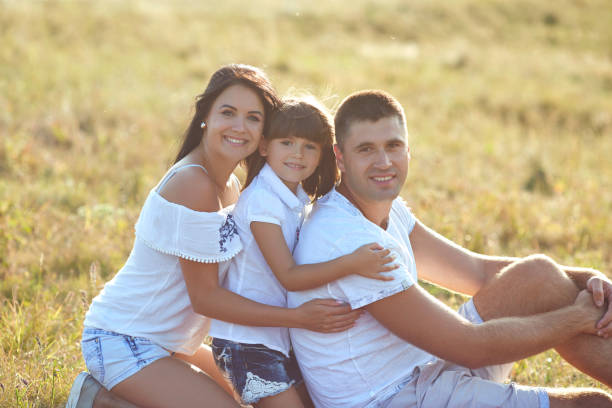 istock Happy family on a picnic outdoors at sunset. 1318652411