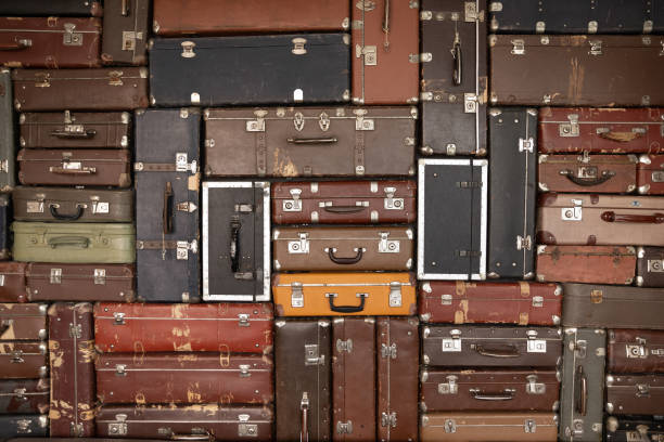 istock Number of old antique suitcases on wall background 1318654263
