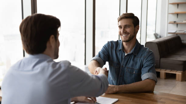 istock Smiling businessmen handshake at negotiations in office 1318655004