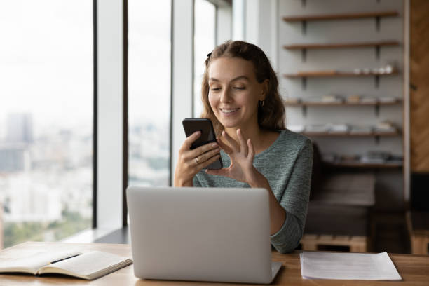 istock Smiling female employee text on modern smartphone in office 1318655055