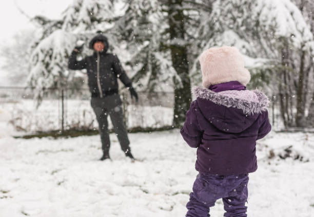 istock Man and child playing on the snow in the yard 1318655189