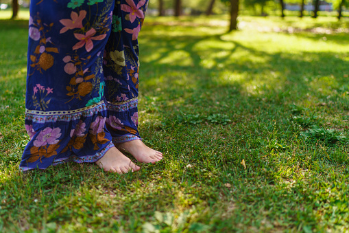 A close-up photo of woman standing barefoot in nature. Earthing or grounding concept.