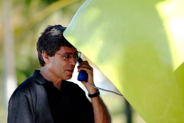 Business communication. Man making a call from public phone. pay phone on the phone latin american and hispanic ethnicity talking stock pictures, royalty-free photos & images