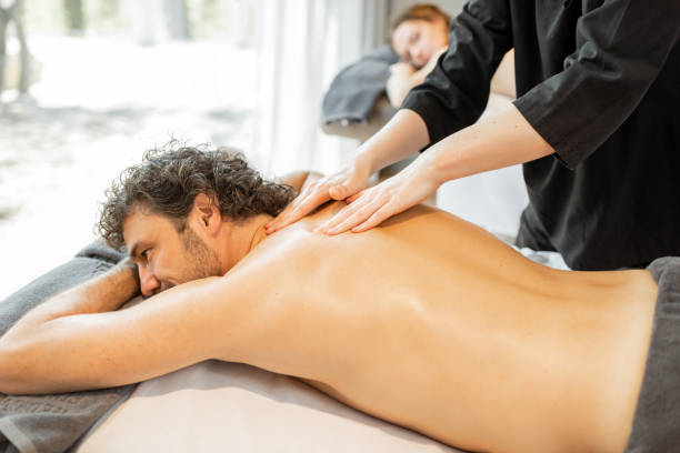istock Beautiful couple lying in a spa salon enjoying getting deep back massage and relaxation. 1318660934