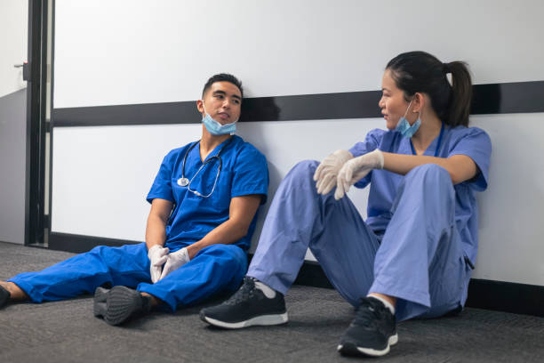 exhausted nurses take a break from their stressful shift - nurse hygiene emotional stress surgeon imagens e fotografias de stock