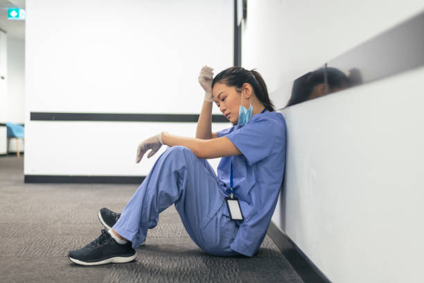 измученные медсестра берет перерыв от ухода за пациентами во время пандемии covid-19. - nurse hygiene emotional stress surgeon стоковые фото и изображения