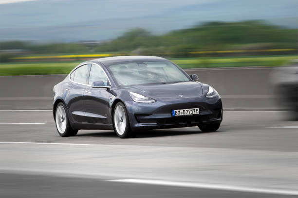 Tesla Model 3 Diedenbergen, Germany - May 12, 2021: Tesla Model 3 on a highway nearby Wiesbaden in Germany. The Tesla Model 3 is an electric four-door fastback mid-size sedan developed by Tesla. Tesla, Inc. is an electric vehicle and clean energy company based in California. tesla model 3 stock pictures, royalty-free photos & images