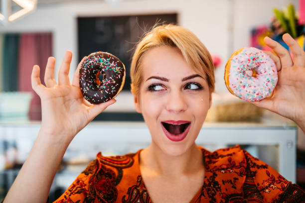 istock Pretty smiling woman holding donuts 1318665338