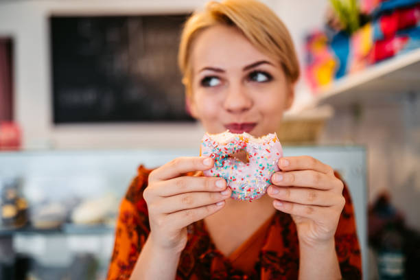 Woman eating donut at the bakery store