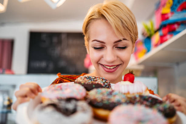 istock Woman looking at donuts at the bakery store 1318666274