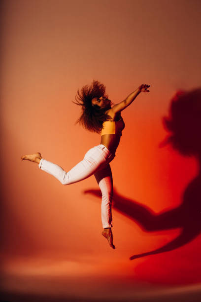 赤い背景にスタジオで踊るフィットネスの女の子。 - dancing dancer hip hop jumping ストックフォトと画像