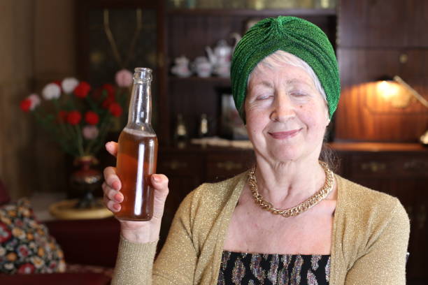 istock Senior woman drinking beer at home 1318668225