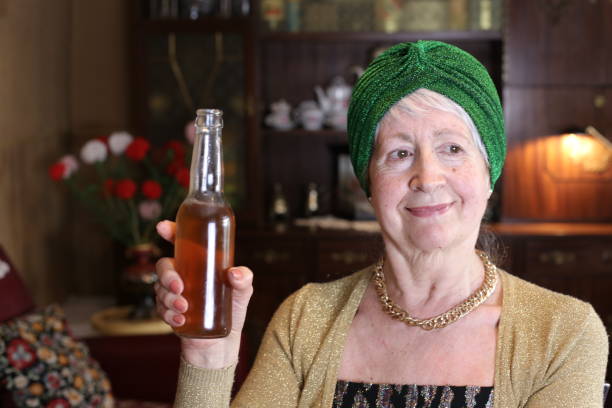 istock Senior woman drinking beer at home 1318668233