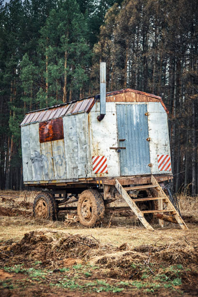 istock Semi trailer house with chimney and steps near pine trees 1318668294
