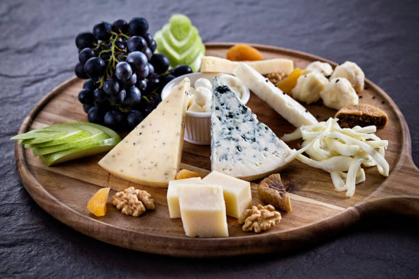 różnorodność serów i winogron na drewnianej desce. - cheese platter zdjęcia i obrazy z banku zdjęć