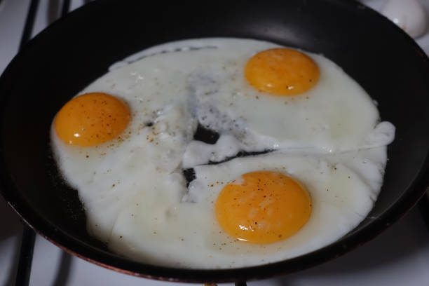 istock Fried eggs being cooked in a frying pan 1318670747