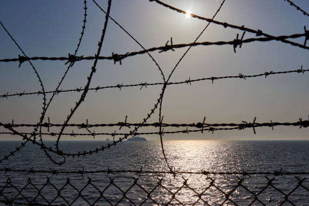 istock Sea and island behind barbed wire 1318673179