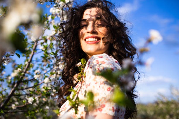 istock A gorgeous woman smiling among spring blossoms 1318673464