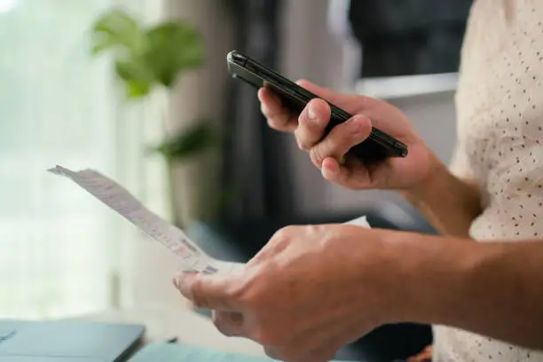 Photo of Senior woman holds various expense bills and plans for personal finances in the living room in her home. stock video