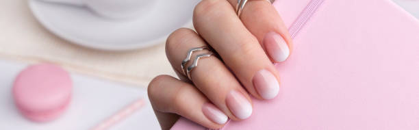 istock Beautiful manicured hand holding notepad at the office table. 1318674799