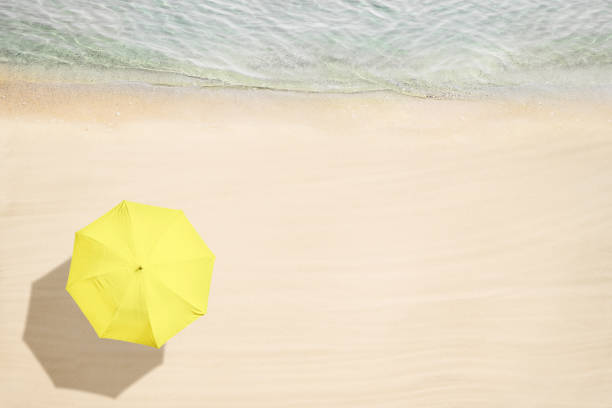 guarda-chuva amarelo na praia de areia tropical. vista superior e aérea. litoral oceânico. foto de drone. fundo - luxary - fotografias e filmes do acervo