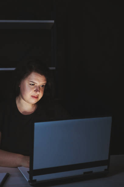 istock Young focused woman doing overtime job at night 1318680916