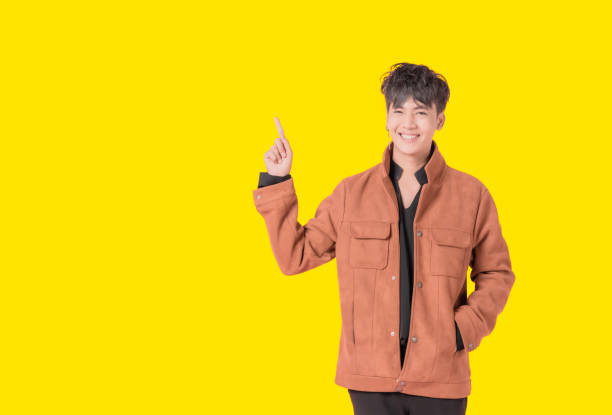 istock and standing posing pointing up with the index finger a great idea isolated on yellow background. 1318681154