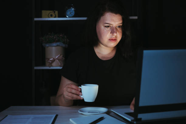 istock Night work. Woman drinking coffee working late 1318681155