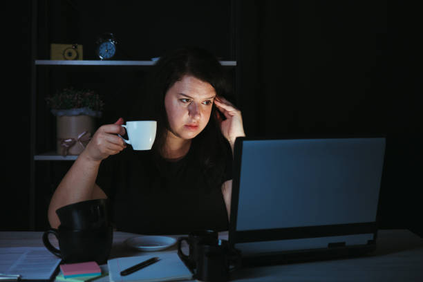 istock Night work. Woman drinking coffee working late 1318681328