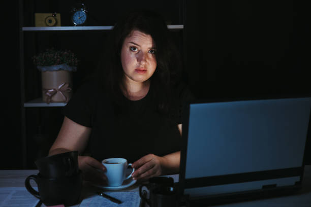 istock Young focused woman doing overtime job at night 1318681346