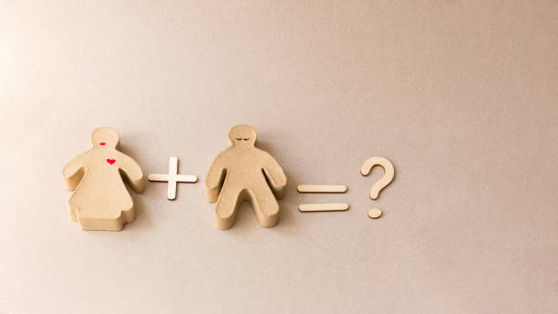 istock Small cardboard man and woman on a brown background. 1318683695