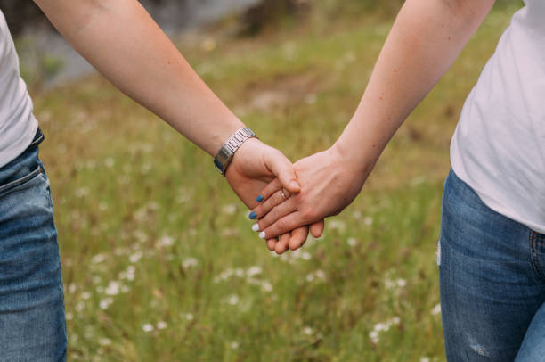 istock loving couple holding hands close up on blurred background 1318684316