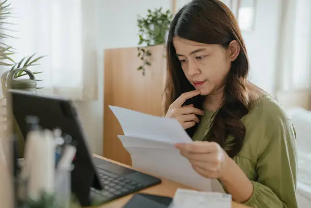 Photo of Mother Using Laptop To Check Finances At Home.