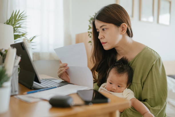 istock Mother Using Laptop To Check Finances At Home. 1318684801
