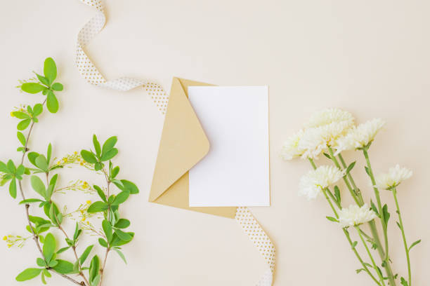 istock Mockup white wedding invitation and envelope with branches and green leaves on color background 1318684981