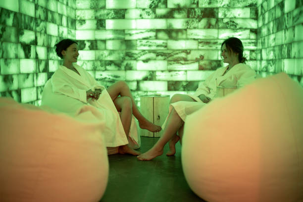 two women in bathrobe sitting and relaxing in salt room - salt room imagens e fotografias de stock